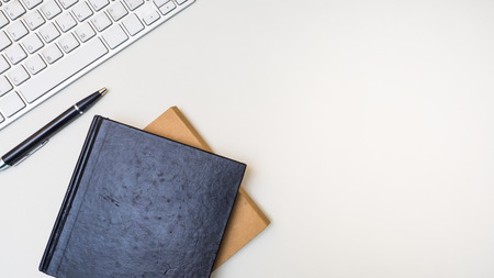 Office desk table with notebook,keyboard,smart phone and pen Top view on white backgroundの写真素材