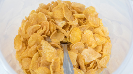 Corn-flakes and spoon close up top view background and texture, cornflake cereal box for morning...