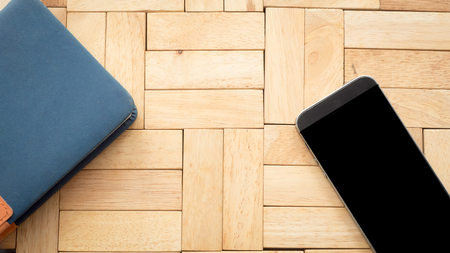 Smart phone and book on wood background or textureの写真素材