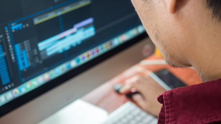 Male Videographer Edits and Cuts Footage and Sound on His Personal Computer.Shift focus