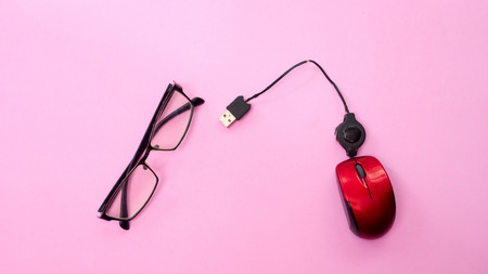 Minimal workplace with computer mouse and  glasses copy space on pastel background. Top view. Flat lay.の写真素材