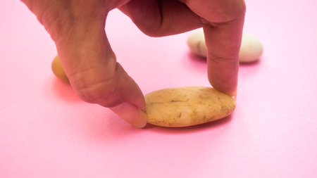 hand with rock on pink backgroundの写真素材