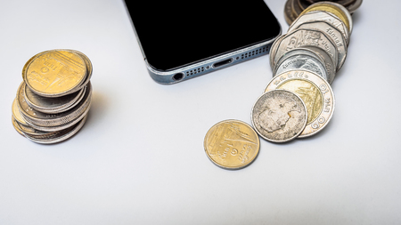 Coin thai bath stacking up with smartphone on white backgroundの写真素材