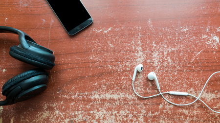 earphone and smart phone on wood table