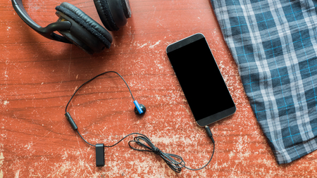 Leather shoes and smartphone, checkered shirt on wood backgroundの写真素材