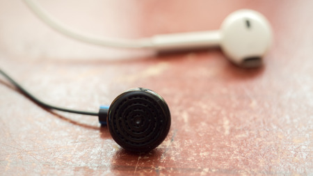 black and white earphone on wood table close upの写真素材