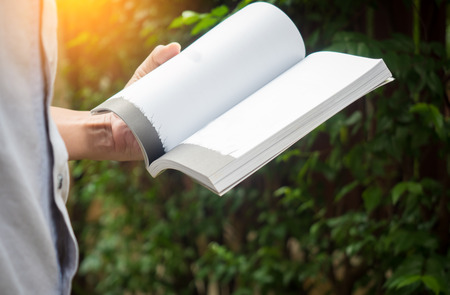 Man reading Book in his hands at gardenの写真素材