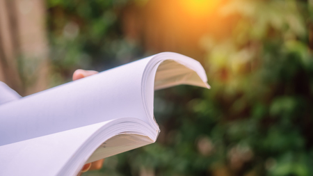 Man reading Book in his hands at garden