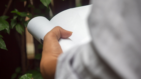 Man reading Book in his hands at gardenの写真素材