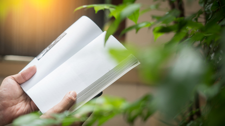 Man reading Book in his hands at gardenの写真素材