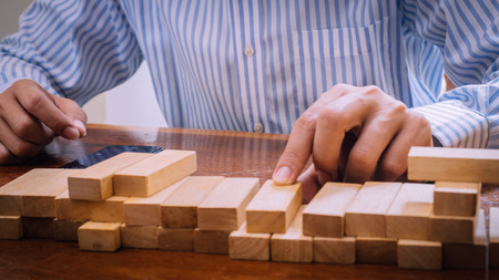 Hand holding wood block , Business concept.の写真素材