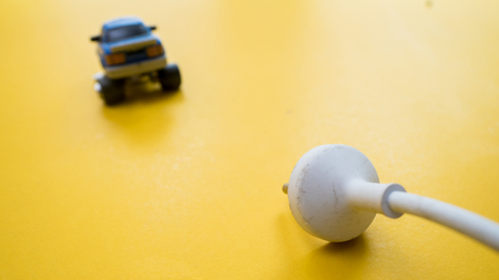 The electric car is connected by a wire with a plug from the socket. Sign symbol