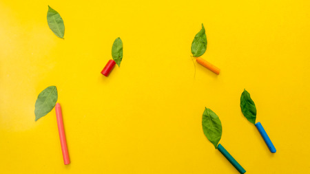 crayon with leaves  on yellow backgroundの写真素材