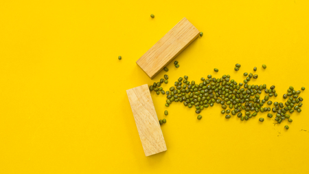 wood block symbol arrow on yellow backgroundの写真素材