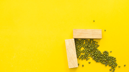 wood block symbol arrow on yellow backgroundの写真素材