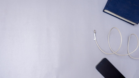 notebook with smart phone and charger on gray background business concept desk tableの写真素材