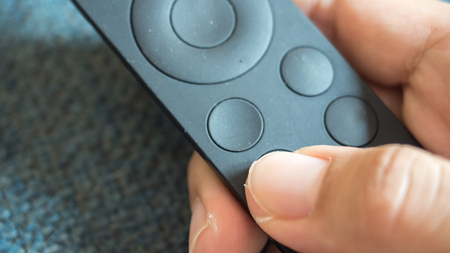 Man press with his finger on remote close up