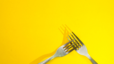 forks and shadow on yellow background