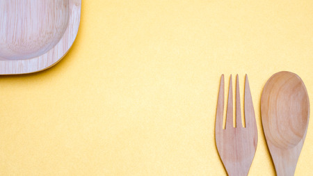 spoon and fork and dish on yellow backgroundの写真素材