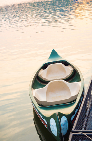tied, empty canoes lie in a row next to each other in a riverの写真素材