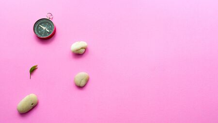 White rock stone and compass on pink background. modern zen conceptの写真素材