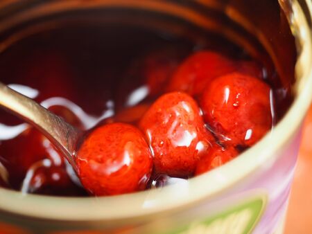 homemade strawberry jam in a glass on spoon close upの写真素材
