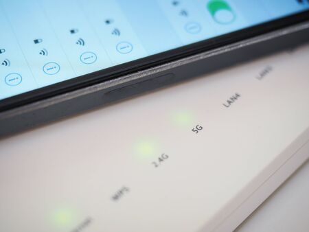 White 5g wifi router and smart phone close upの写真素材