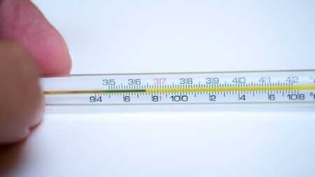 Thermometer with hand on white background