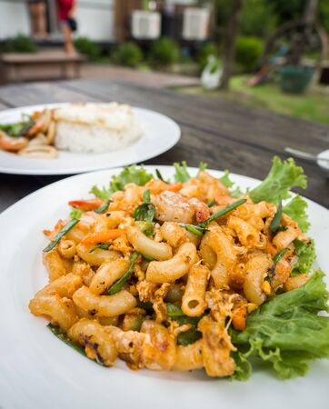 Stir in macaroni and eggs in tomato sauceの写真素材