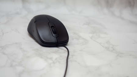 A black mouse on a marble floorの写真素材