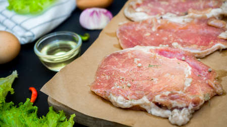 Fresh meat. Raw pork steak with spices on black backgroundの写真素材