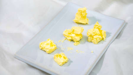 Cubes Of Cheddar Cheese On White backgroundの写真素材