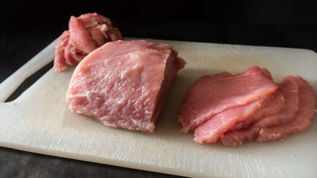 Large pieces of raw raw pork black backgroundの写真素材