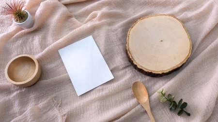 container, with Wooden cutting board, white card, flowers on a fabric background, packaging mockup with empty space to display your branding design.の写真素材