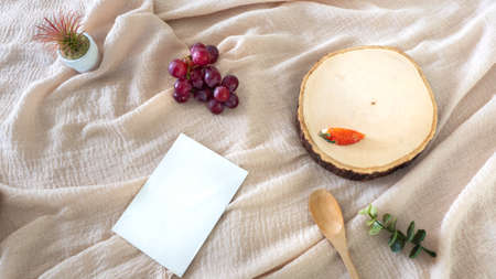 container, with Wooden cutting board, white card, strawberry on a fabric background, packaging mockup with empty space to display your branding design.の写真素材