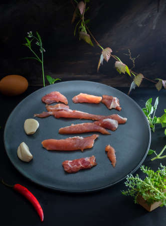 Raw pork, fresh beef, chilli and garlic on black backgroundの写真素材