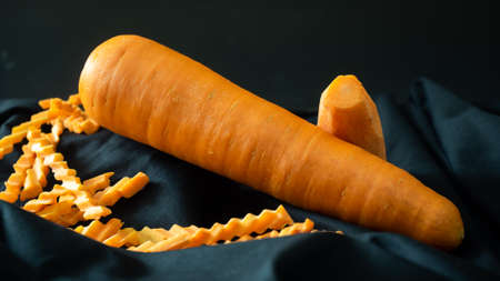 Fresh big carrot bunch on dark stone table or black background top view, copy space.の写真素材