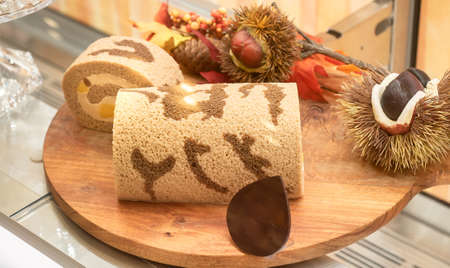 Delicious biscuit roll with apricot jam on a wooden table. Cutting  Dessert for breakfast.の写真素材