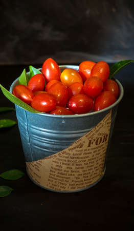 Fresh tomatoes in a plate on a dark background. Harvesting tomatoes.の写真素材