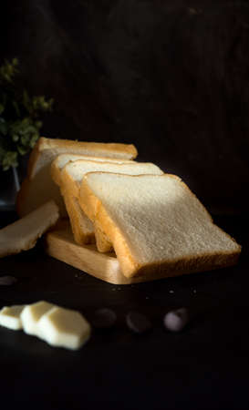 Bread on a black background. Three slices of sliced breadの写真素材