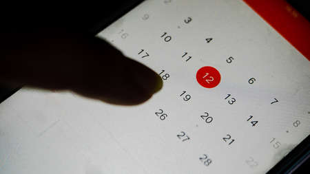 Mobile Calendar in smarth phone with hand close up