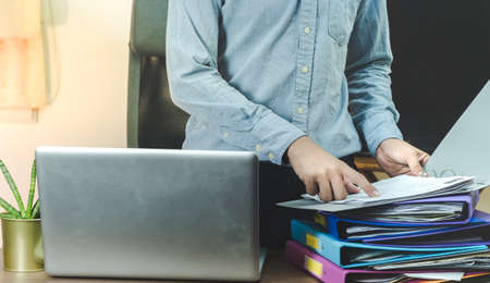 a business man holding a business folder and pointing his finger at a business document.business nature conceptの写真素材
