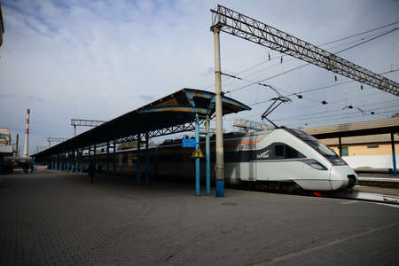 ZAPORIZHIA, UKRAINE - MARCH 24, 2019: High speed train at the railway station at sunset in Europe. Modern intercity train on railway platform.のeditorial素材