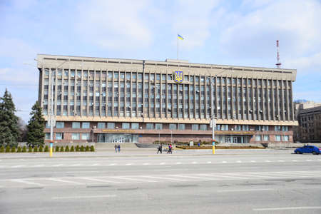 ZAPORIZHIA, UKRAINE - MARCH 24, 2019: Zaporizhia regional state administration building with Ukrainian flag waves at the beautiful sunny day. Ukrainian flag with ukrainian symbol.のeditorial素材