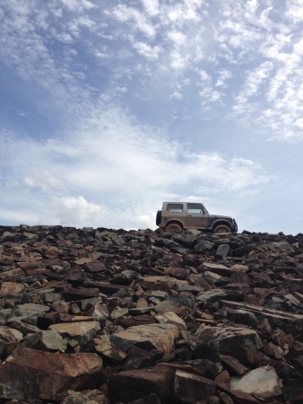 dirty jeep on rocky hillの素材