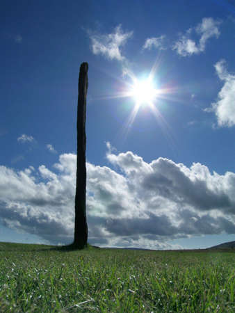 One of the standing stones at Stennis, Orkney, surrounded by grass and framed by a sculpted skyの写真素材