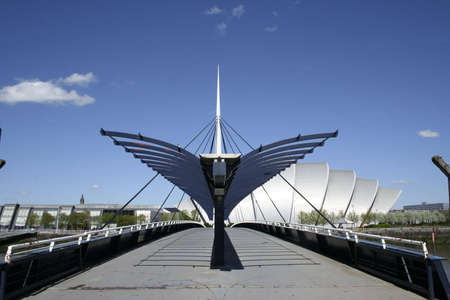 View along a pedestrian bridge across the River Clyde, Glasgow. The 'Armadillo' is beyondの写真素材