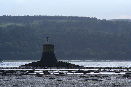 One of the navigation beacons in the Clyde Estuary at low tide, near Dumbarton, Scotlandの写真素材