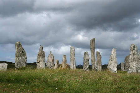 Sunlit Standing Stones at Calanais under a heavy cloud cover, Western Isles, Scotlandの写真素材