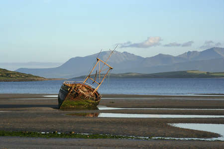 A derelict fishing boat at Ettrick Bay, Bute, with the island of Arran in the background